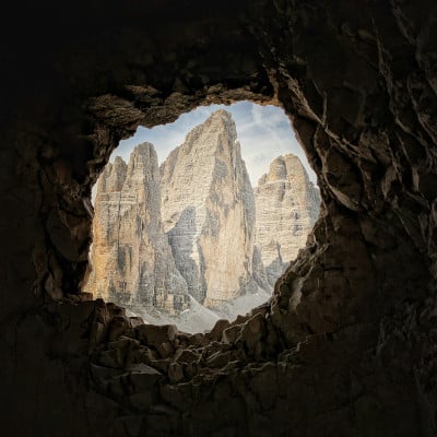 Blick aus runder Höhle auf Berggipfel als Bild für Analsex